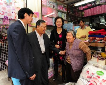 Executive Director (Operations & Project Control) of the URA, Calvin Lam (first left) and Director (Acquisition & Clearance) of the URA, Joseph Lee (second left) talking to one of the shop operators. 