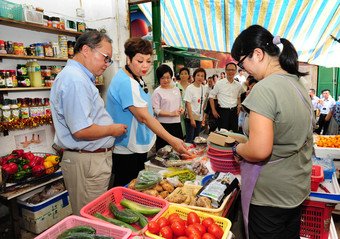 URA Board Member and Chairman of URA’s Central and Western District Advisory Committee, Mr Edward Chow (left) and artist Ms Maria Cordero (right) visit Graham Street Market together with other guests.