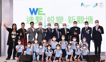 Officiating guests and three members of Grasshoppers who grew up in Kwun Tong, take a group photo with the 14 performing students from five local primary schools at the opening ceremony today.